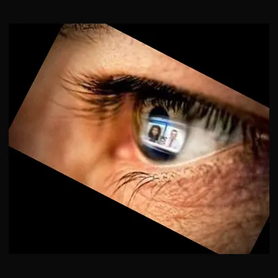 A close-up of a human eye with small photographs reflected in the iris.